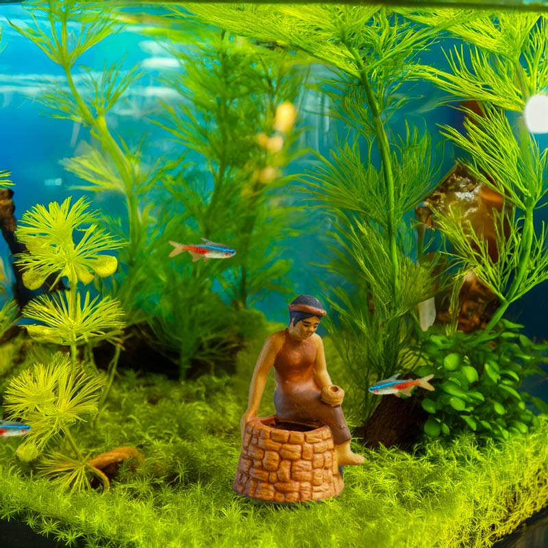 A miniature Tam figurine sits beside a ceramic well, adding a touch of Vietnamese charm to a vibrant underwater world filled with lush green plants and playful fish.