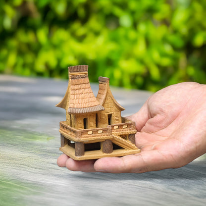  Held gently in a hand, this tiny Vietnamese stilt house, crafted from earthen-toned ceramic, showcases the intricate detail and cultural heritage of these unique homes.