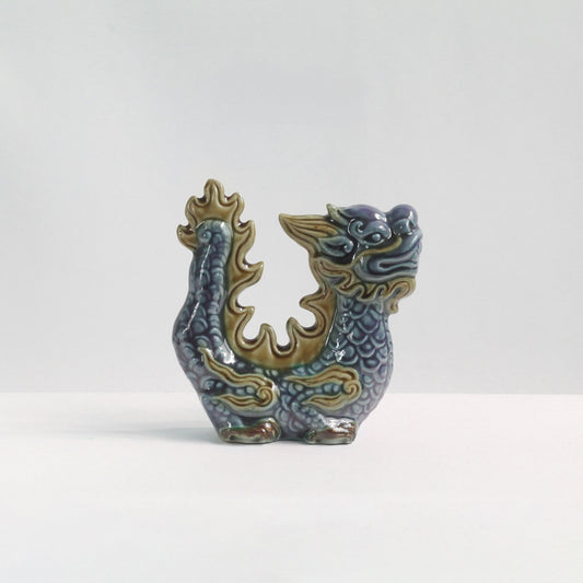 Side view of a blue-glazed handmade ceramic dragon. A unique office desk dragon figurine.