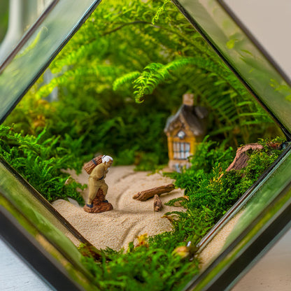 A tiny woodcutter figurine ventures through a miniature forest within a glass terrarium, his journey adding a touch of whimsy and storytelling to this enchanting display.