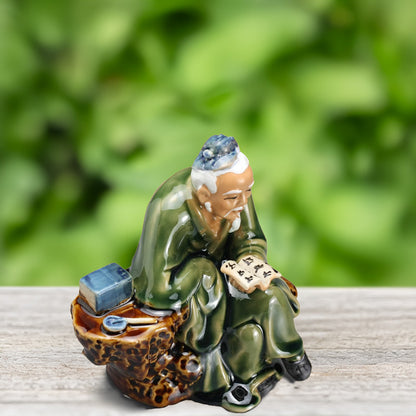 Crafted with meticulous detail, this miniature ceramic scholar, dressed in traditional Vietnamese attire, pores over an ancient text, adding a touch of cultural richness to your bonsai.