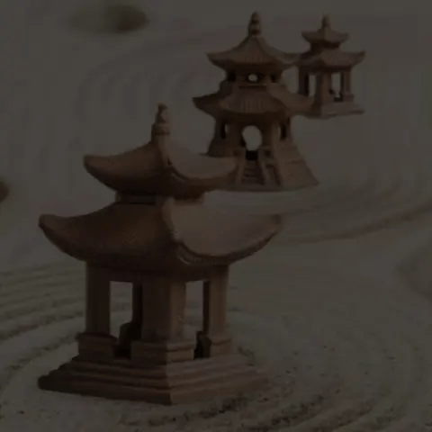 Three miniature Japanese pagoda Bonsai figurines in a sand Zen garden decor display.