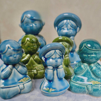 Group of small Vietnamese ceramic children figurines in blue and green ao dai