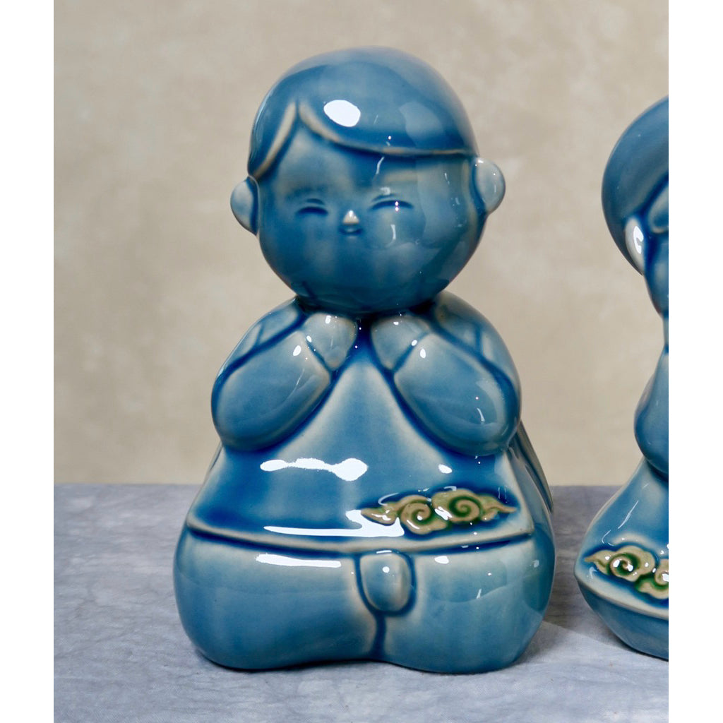Close-up of a blue-glazed seated Vietnamese boy figurine in ao dai