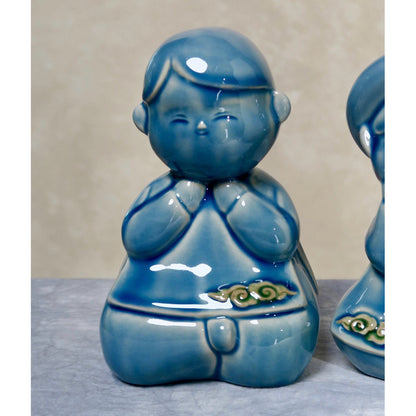 Close-up of a blue-glazed seated Vietnamese boy figurine in ao dai