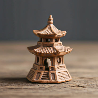Small ceramic japanese pagoda on a wooden surface with a blurred background
