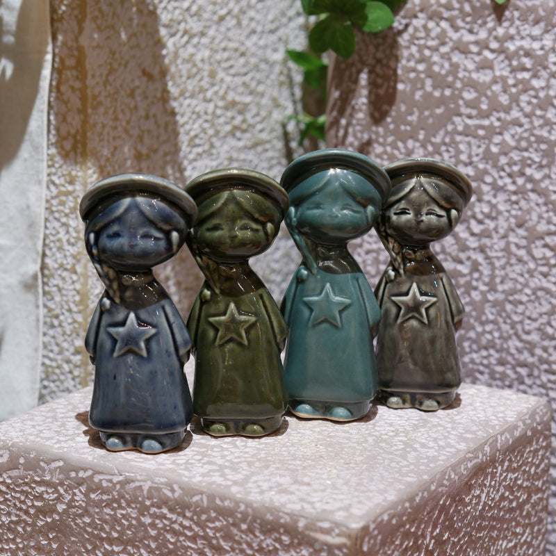 Four Vietnamese ceramic star child figurines in blue, green, teal and gray